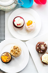 Colorful delicious cupcakes on plates,top view