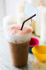 Ice coffee with milk foam on table