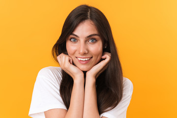 Image closeup of adorable brunette woman with long hair smiling and touching her cheeks