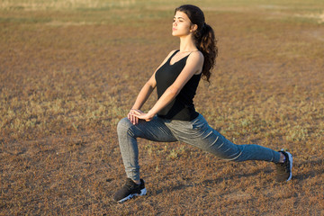 A young slim athletic girl in sportswear with snakeskin prints performs a set of exercises. Fitness...
