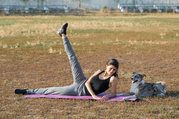 A young slim athletic girl in sportswear with snakeskin prints performs a set of exercises. Fitness...
