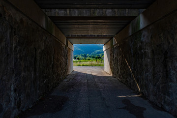 Fototapeta na wymiar Rail over-bridge creating a tunnel opening up to the french countryside
