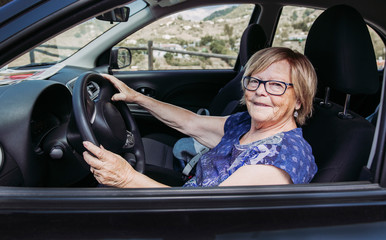 grandmother using her car and takes a good smile