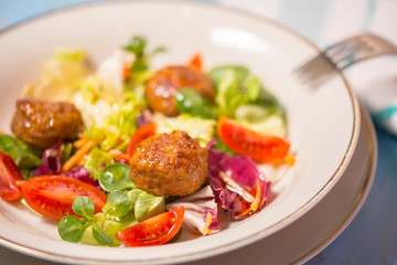 Colorful fresh vegetable salad with meatballs. Close-up photo