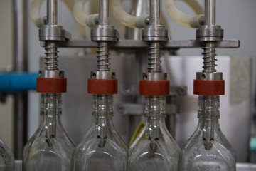 close up machines filling fresh water to glass bottles