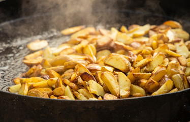 fried potato cooking process on large cast iron pan outdoor tasty food picture 