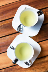 Hot green tea in cups top view