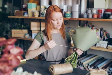 Tying flower bouquet in green paper