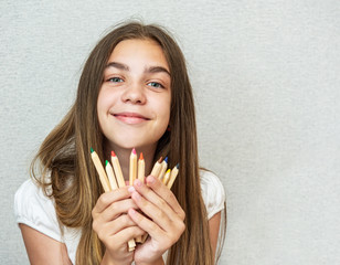 Girl holding pencils in front of face