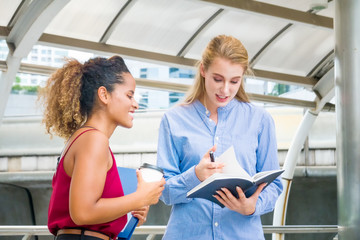 Fototapeta premium business women looking at book while discuss with friend