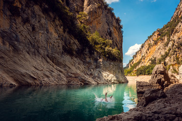 Man jumping into the water of a gorge in the Pyrenees mountains