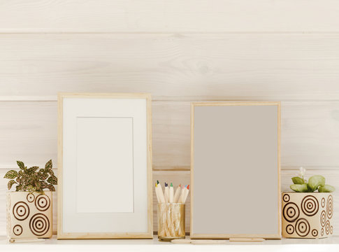 Mock up wooden frames, colorful pencils, houseplants on a white shelf or table on a wooden background