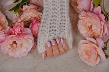 ideally made manicure. Women's hands on the background of flowers