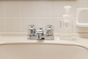 Washbasin and hand soap in the white bathroom of the hotel