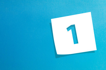 Note paper with number one on blue background 