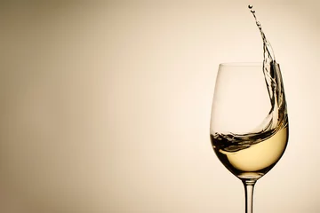 Poster Zwevende druppels en scheutje witte wijn in glas © sergign