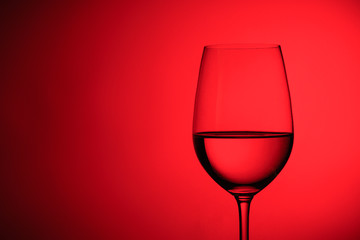 Naklejka na ściany i meble Glass of wine over a red background