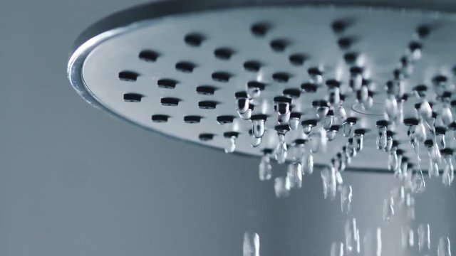 Water falling from the rain shower in the bathroom select focus shallow depth of field dark and grain processed
