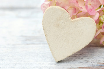 Obraz premium white heart and flowers Hydrangea lying on wood