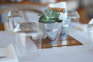 Table decoration in a restaurant, tablecloth, flowers, bucket, inverted glass