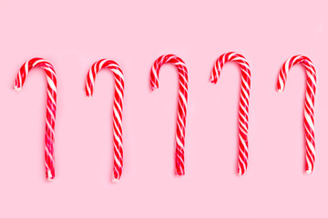 Christmas candy cane on pink background. Flat lay