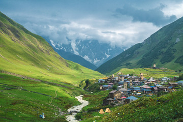 View of the Ushguli village at the foot of Mt. Shkhara. Picturesque and gorgeous scene. Rock tower towers and old houses in Ushguli. - 286062039