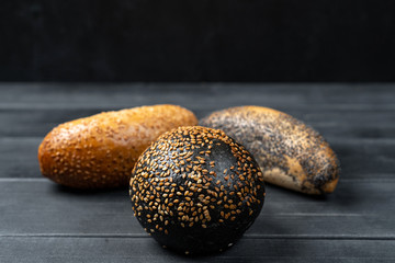 rye and wheat baguettes on black wooden table.