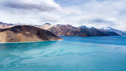 Blue Ice surface of Frozen Lake from drone aerial view at Pangong Lake or Pangong Tso, Tso moriri – Nubra, India. Abstract concept of Cold winter, peaceful and freedom.