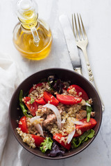 salad quinoa with tuna, tomato and lettuce in brown bowl