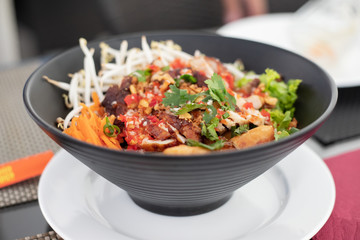 chinese salad in black bowl in restaurant