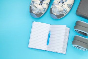 Flat lay of sport and fitness equipment on yellow background with copy space.