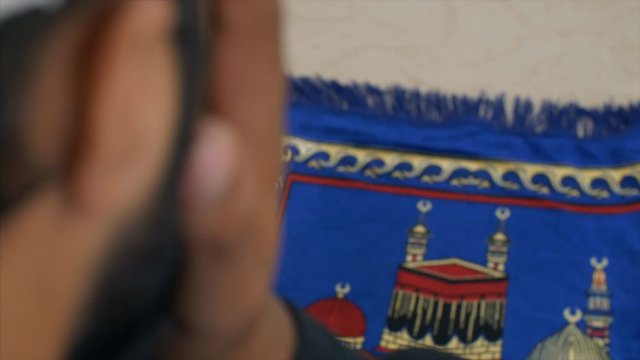 Close-up shot of a Muslim man doing namaz on Jai Namaz - Ramzan  Ramadan. HD stock footage of man sitting on a praying mat and offering namaz 