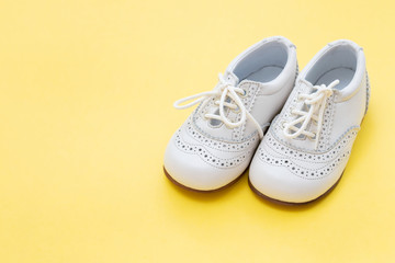 white baby shoes on yellow background