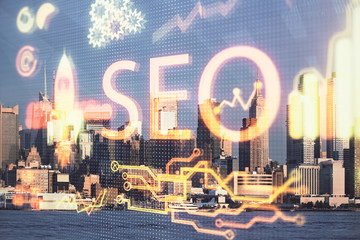 SEO hologram on city view with skyscrapers background double exposure. Search optimization concept.