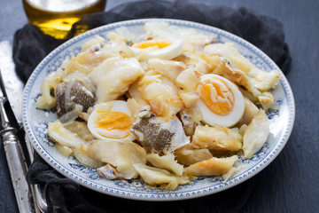 cod fish with onion, eggs and olive oil on dish