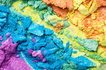 A broken rainbow colored eye shadow smear, make up palette isolated on a white background.