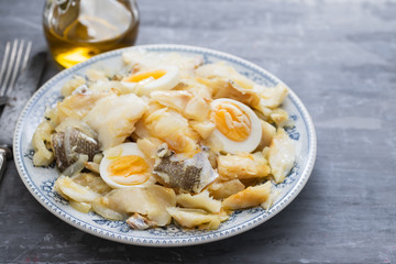 cod fish with onion, eggs and olive oil on dish