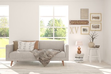 Stylish room in white color with sofa and summer landscape in window. Scandinavian interior design. 3D illustration