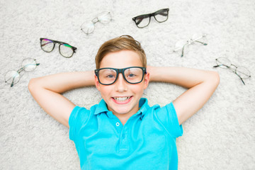 Happy handsome child boy trying on glasses. Health, medicine and ophthalmology concept