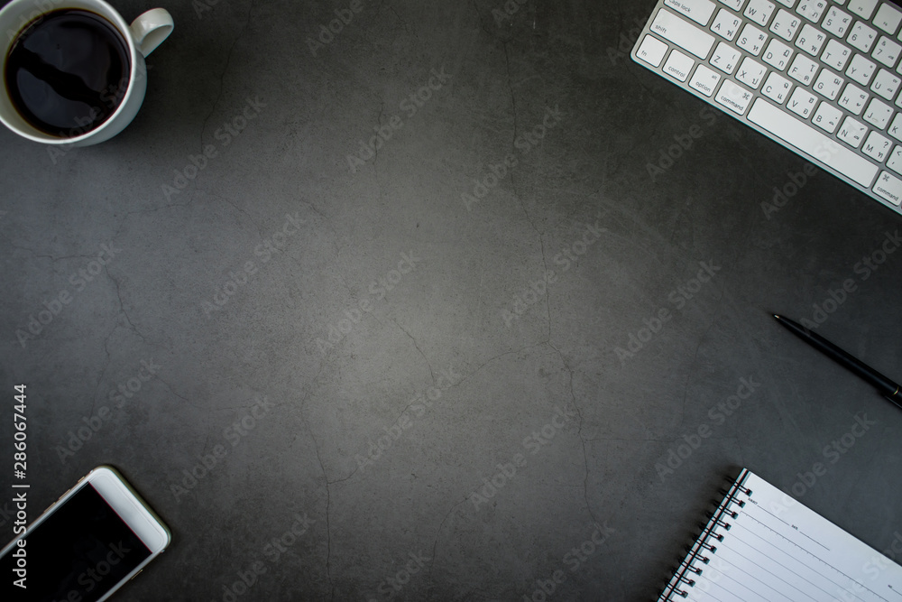 Poster top view of modern black desk with accessories and copy space in the middle of the image.