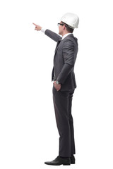 serious businesswoman in helmet pointing at copy space . isolated on white