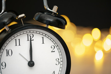 Close up of retro alarm clock on blurred Christmas background with bokeh