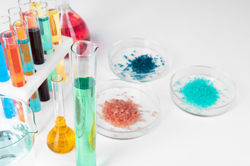 Colored liquids inside lab glassware on white table in laboratory