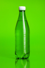 Crystal clear water in a bottle on green background