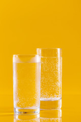 Glass of water on yellow background. Healthy lifestyle