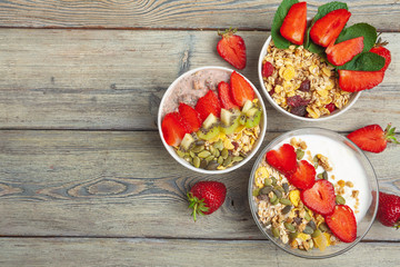 Healthy breakfast with yogurt, berries and granola on wooden table top view