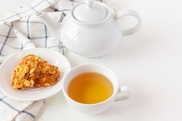 Cup of tea with cookies over lilac wooden background