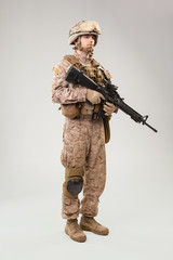 Studio shoot of modern infantry soldier, U.S. marine rifleman in combat uniform, helmet and body armor