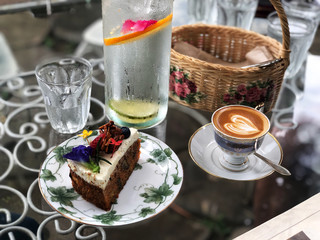 Delicious Breakfast;  Piccolo Latte coffee  and Carrot cake in beautiful plate. Natural dark light and vintage style.