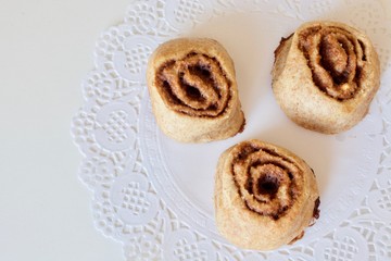 Tasty sweet cinnamon buns on the white table.